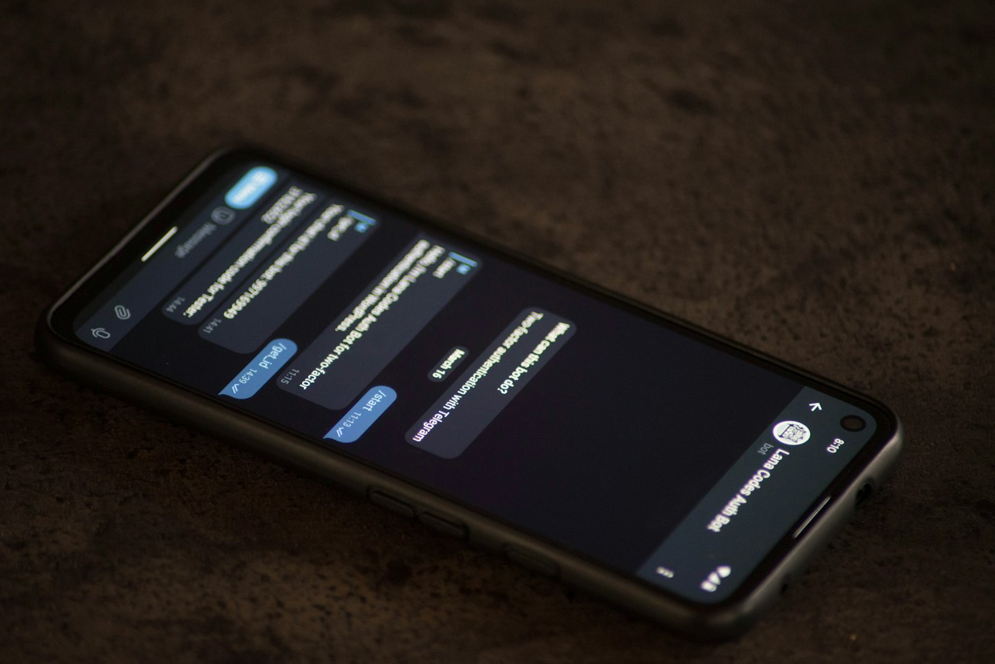 Modern smartphone displaying two-factor authentication chat messages on a desk.